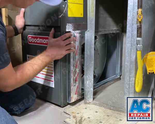 The image depicts our professional technician diagnosing and repairing a non-functional furnace unit in San Ramon, CA. The technician is shown carefully inspecting the furnace to pinpoint the issue. Following the diagnosis, he is seen performing precise repairs to restore the unit's functionality. Additionally, the technician meticulously checks the voltage levels of the furnace blower motor, ensuring it operates correctly. After completing the repairs, he also verifies the heat output of the furnace, confirming that it is working efficiently and safely. This image is a direct link to our furnace repair service page, providing detailed information about our specialized furnace repair services in San Ramon, CA.